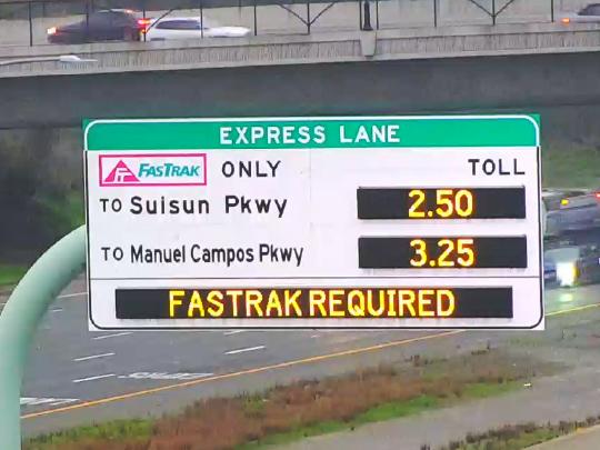 A variable messaging sign over a freeway that says "FasTrak Required"