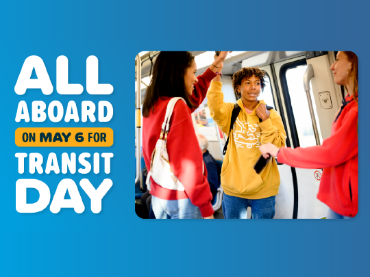 People standing on a BART train talking with "All Aboard on May 6 for Transit Day" written on the left