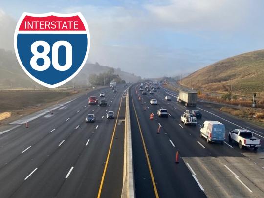 picture of interstate 80 with traffic on both sides and fog in the background