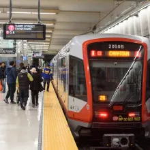 Commuters board a car at the Third Street Chinatown stop