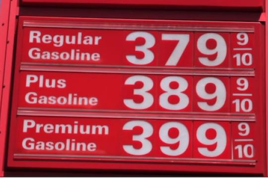 A red sign with gas prices
