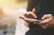 A close up of someone's hands operating a smartphone