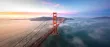 An aerial view of the Golden Gate Bridge with Karl the fog running under it and a beautiful sky with hues of pink yellow and blue in the background