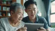 a young man helping a senior woman use a tablet