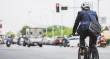Someone in a suit riding a bicycle in traffic