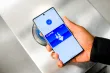 A hand holding a phone showing the Clipper card.