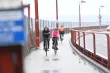 People riding bicyles on a bridge