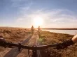 Three people riding bikes into the sunset