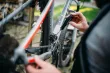 A hand holding a screwdriver fixing a bike.