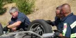 Technicians on the road inspecting a flip over vehicle