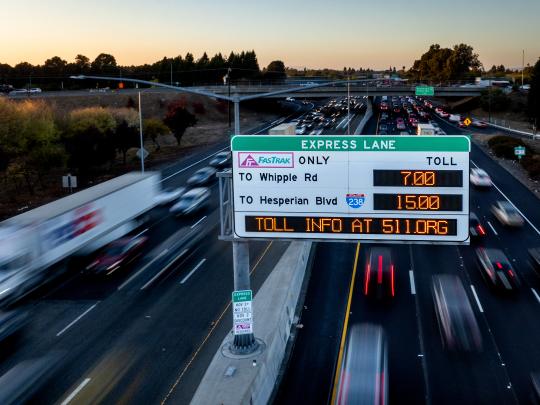 Highway traffic and an express lane variable toll messaging sign